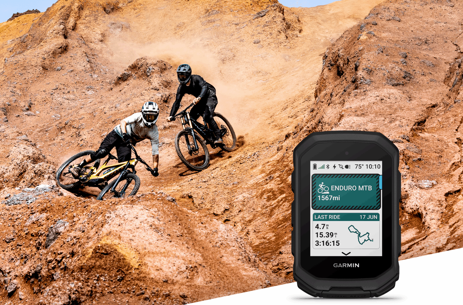 urządzenie garmin edge mtb na pierwszym planie i dwie osoby na rowerze, zdjezdzajace z piaszczystej gory