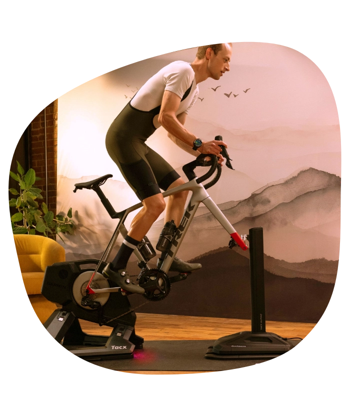 Symulator nachylenia tacx alpine. Kolarz trenuje w pomieszczeniu, widok jazdy pod górkę.
